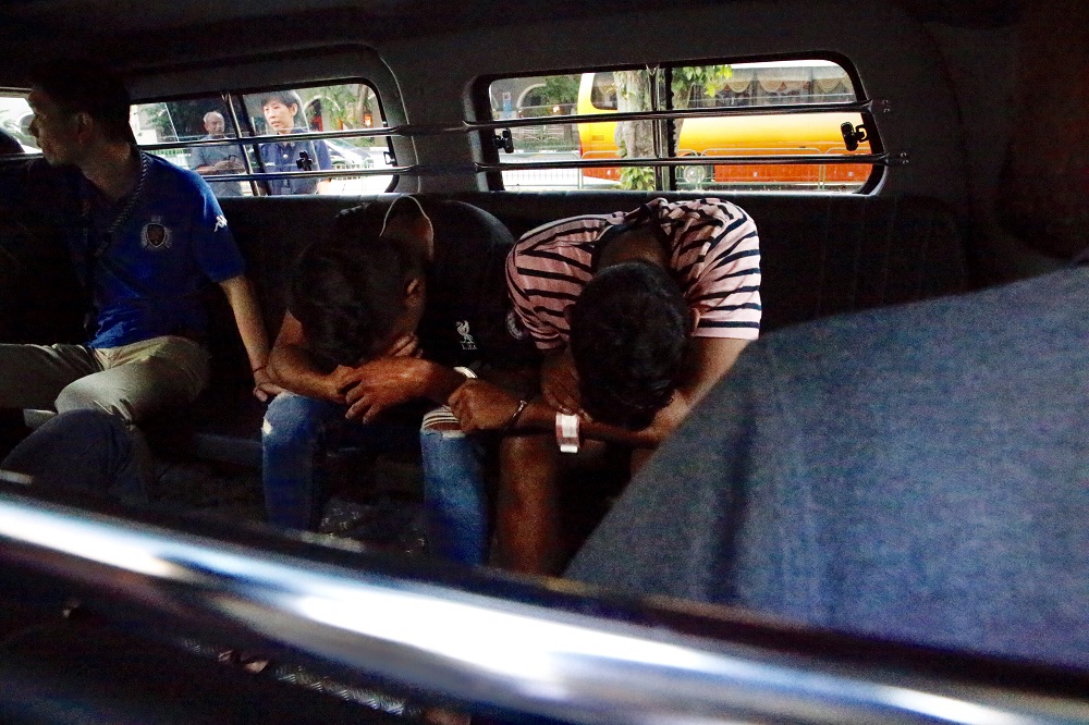 The suspects in the Serangoon slashing case arriving at the State Courts on Friday in a police van. They have been charged with the offence of rioting armed with deadly weapons. 