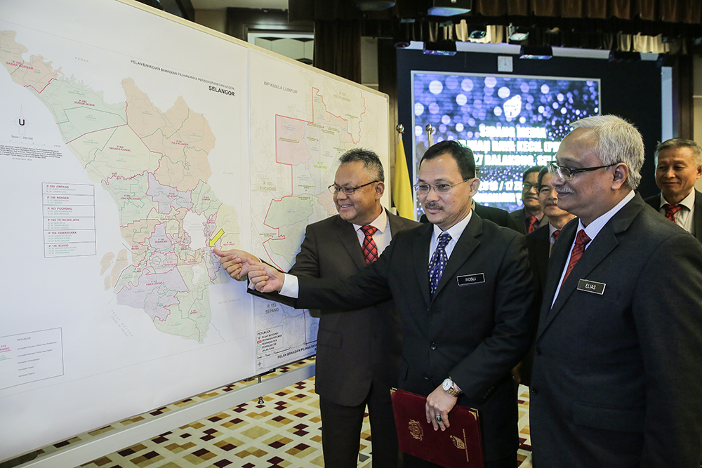 Election Commission deputy chairman Tan Sri Othman Mahmood (left) referencing the Balakong area during a press conference in Putrajaya July 30, 2018.