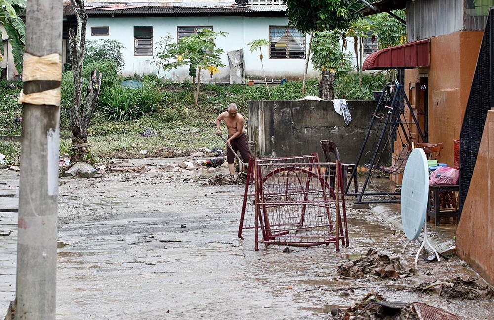 A man clears garbage from his home after a flash flood in George Town July 30, 2018. u00e2u20acu201d Picture by Sayuti Zainudin