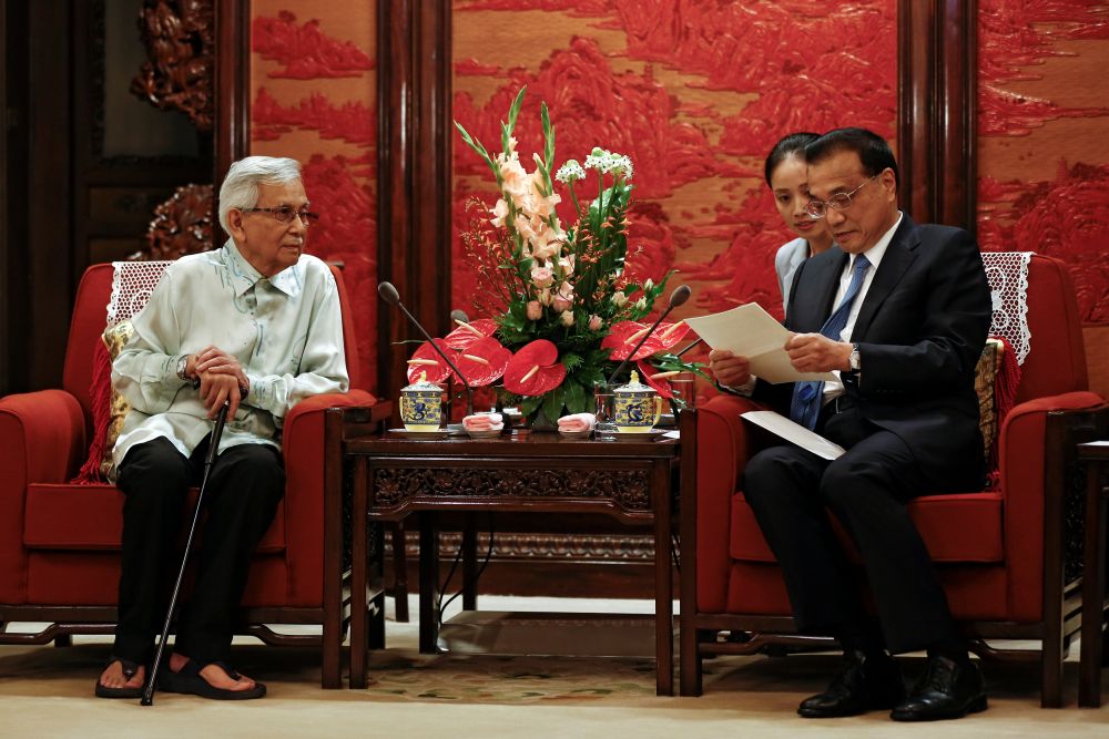 Chinese Premier Li Keqiang looks at a letter given by Malaysia's Prime Minister Tun Mahathir Mohamad during a meeting with Tun Daim Zainuddin in Beijing, July 18, 2018. u00e2u20acu201d Reuters