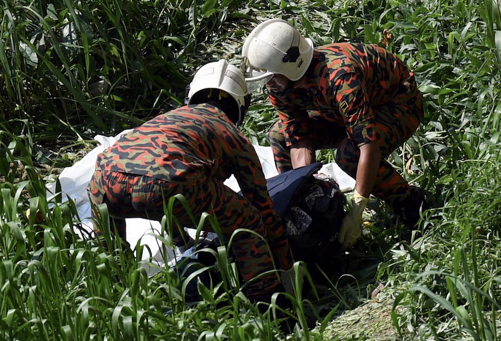 Fire and Rescue Department personnel retrieve one of the suitcases found on the banks of Gombak River near Putra World Trade Centre in Kuala Lumpur July 5, 2018. u00e2u20acu201d Bernama pic