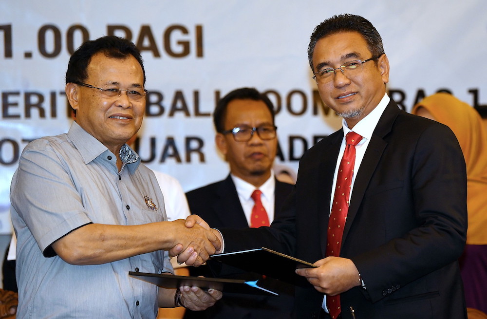 Johor Mentri Besar Datuk Osman Sapian and Melaka Chief Minister Adly Zahari shake hands at the signing ceremony in Muar July 24, 2018. u00e2u20acu201d Bernama pic