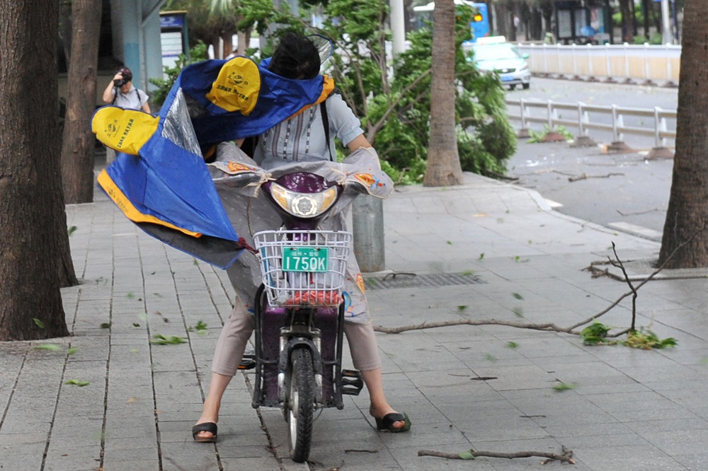 A woman riding an electric bicycle braces herself against strong wind brought by Typhoon Maria on a street in Fuzhou, Fujian province, China July 11, 2018. u00e2u20acu201d China Daily via Reuters pic