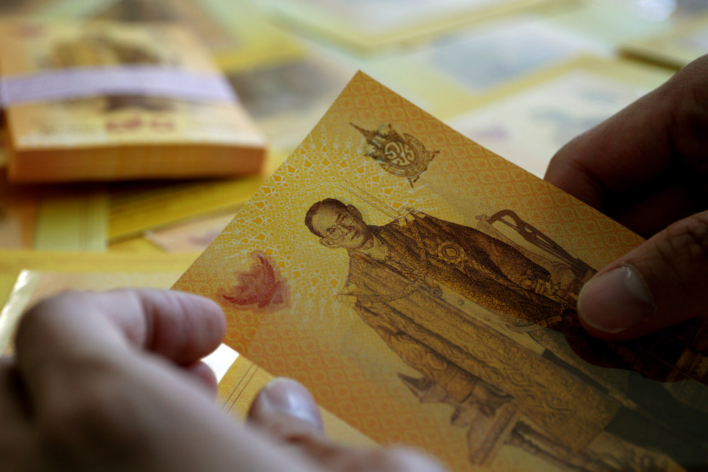 A bank employee puts new 70 baht bank notes into an envelope before selling the notes printed by the Thai Central Bank in Bangkok June 8, 2016. u00e2u20acu201d Reuters pic 