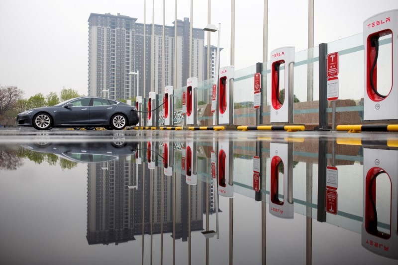 Zang Yi charges her Tesla car at a charging point in Beijing April 13, 2018. u00e2u20acu201d Reutersn