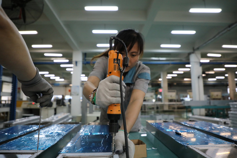 A woman mounts elevator panels inside a factory of a company manufacturing elevators in Shenyang, Liaoning province June 14, 2018.  u00e2u20acu201d Reuters pic