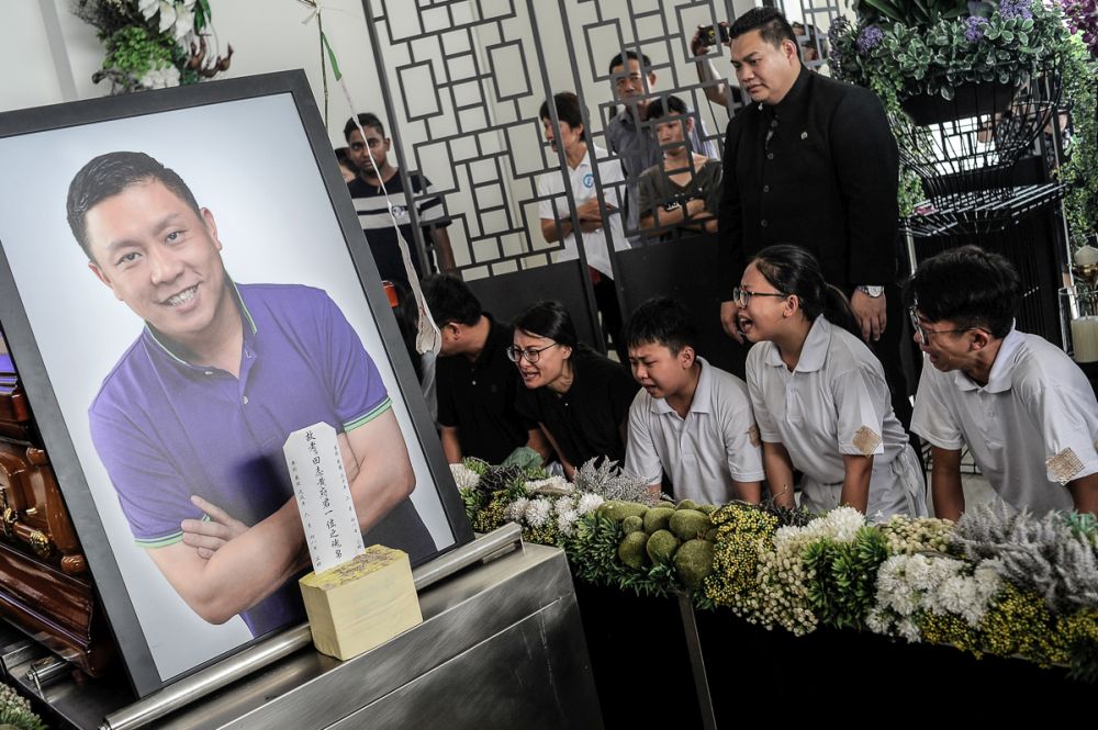 Eddie Ng’s children mourn his passing at the Xiao En Memorial Park in Nilai July 24, 2018. — Picture by Shafwan Zaidon