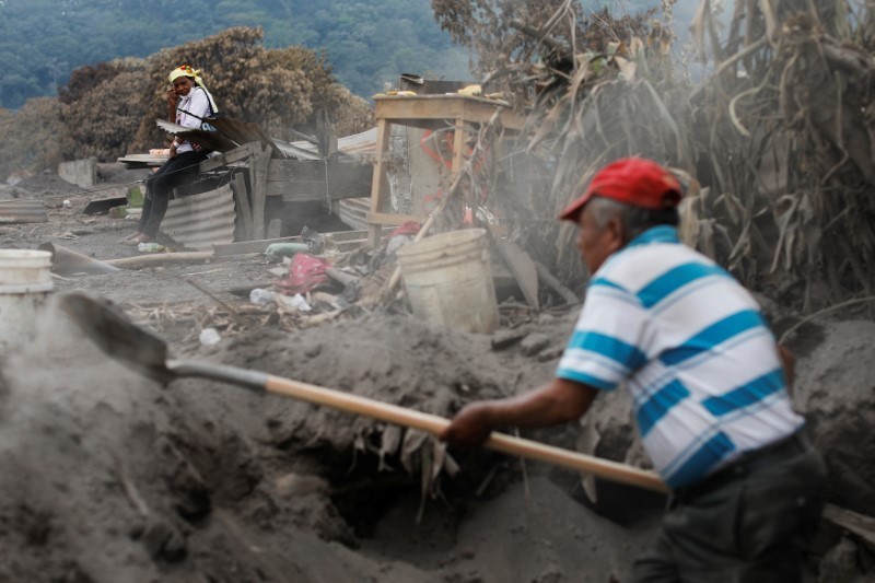 Eufemia Garcia, 48, who lost 50 family members during the Fuego volcano eruption, observes a volunteer who is aiding her in the search for her family in San Miguel Los Lotes, Guatemala, June 11, 2018. u00e2u20acu201d Reuters pic