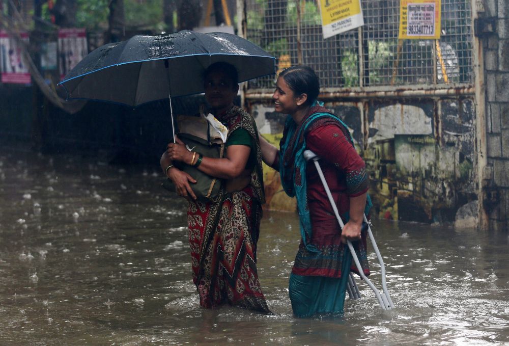 People wade through a waterlogged street during heavy rains in Mumbai July 10, 2018. u00e2u20acu201d Reuters pic