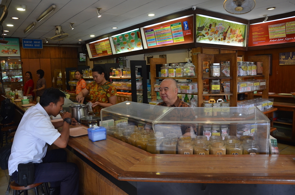 Rohmuli serves a customer at his shop in Salemba. — Jakarta Globe pic