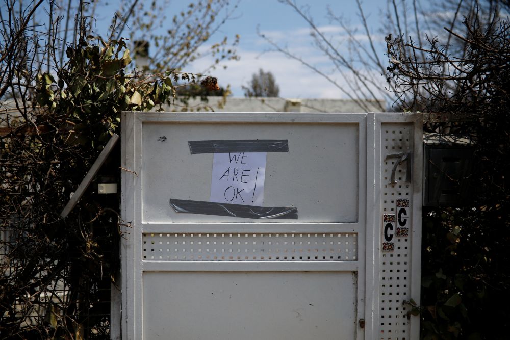 A handwritten note reading u00e2u20acu02dcWe are OKu00e2u20acu2122 is posted on the entrance of a house following a wildfire in the village of Mati, near Athens. u00e2u20acu201d Reuters pic