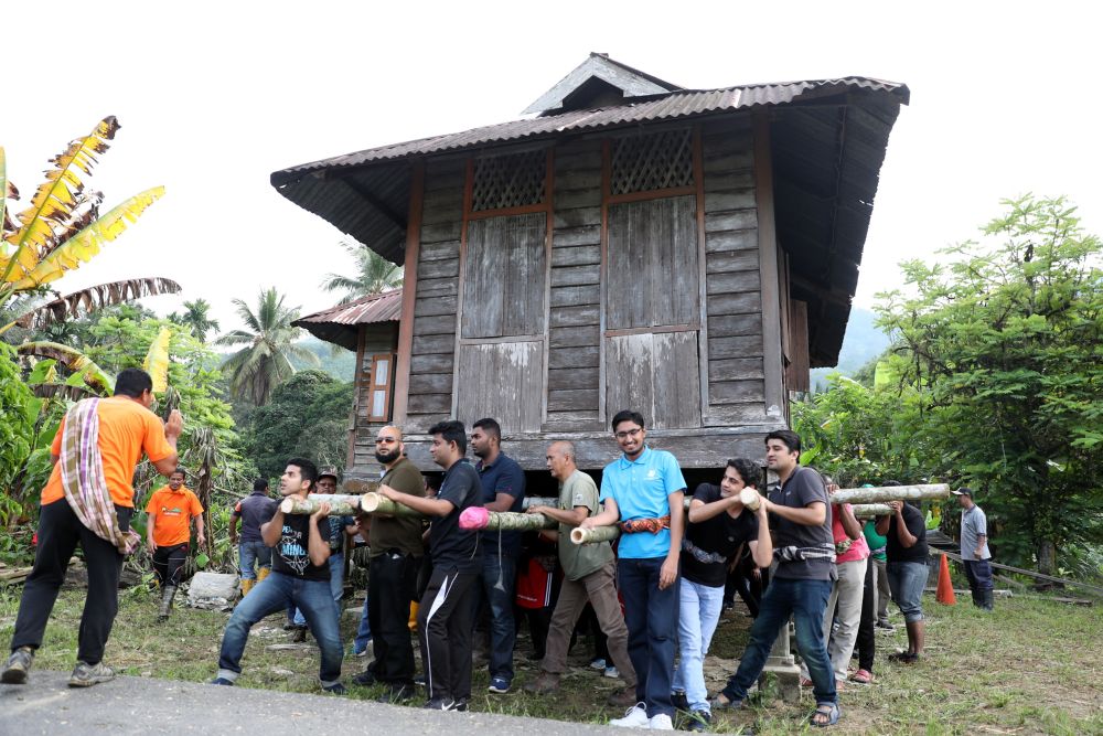 Foreign students from Universiti Teknologi Petronas and Universiti Sultan Azlan Shah carrying the wooden house in Kampung Labu Kubong, Lubuk Merbau, Kuala Kangsar. u00e2u20acu2022 Picture by Perak Today