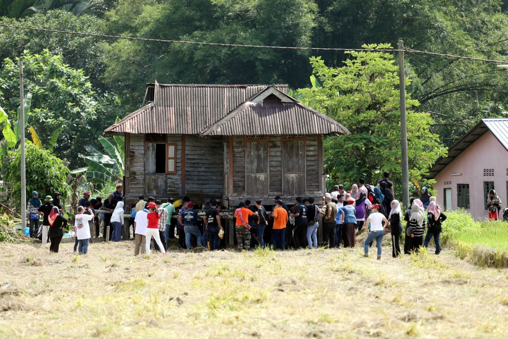 Villagers and university students join hands to relive the tradition of moving a wooden house in Kampung Labu Kubong, Lubuk Merbau, Kuala Kangsar. 