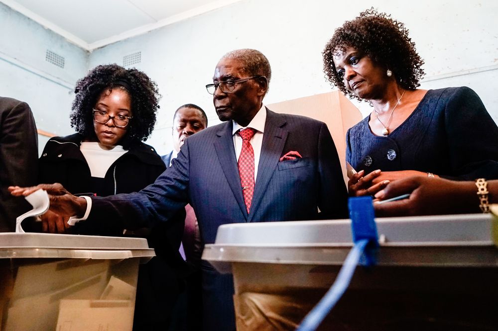 Former Zimbabwean president Robert Mugabe (centre) is watched by his daughter Bona (left) and wife Grace as he casts his vote at a polling station in Harare during the country's general elections, July 30, 2018. u00e2u20acu201d AFP pic