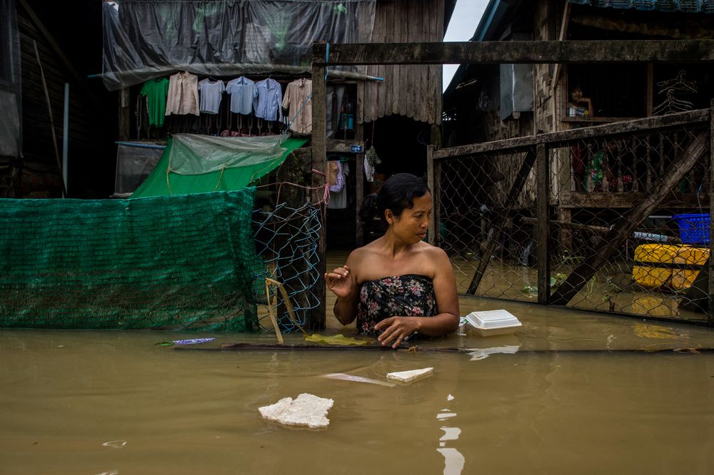 A woman walks through floodwaters in the Bago region, some 68 km away from Yangon, on July 29, 2018. Heavy monsoon rains have pounded Karen state, Mon state and Bago region in recent days and show no sign of abating. u00e2u20acu201d AFP pic