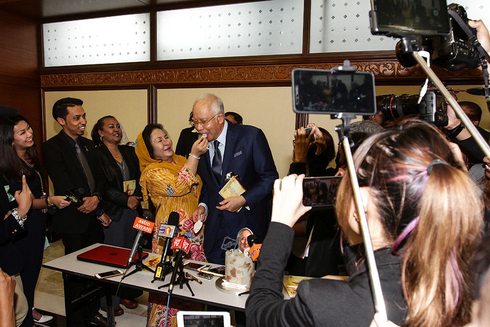 Datuk Seri Najib Razak is fed a piece of cake by his wife Datin Seri Rosmah Mansor in Parliament July 23, 2018. — Picture by Miera Zulyana