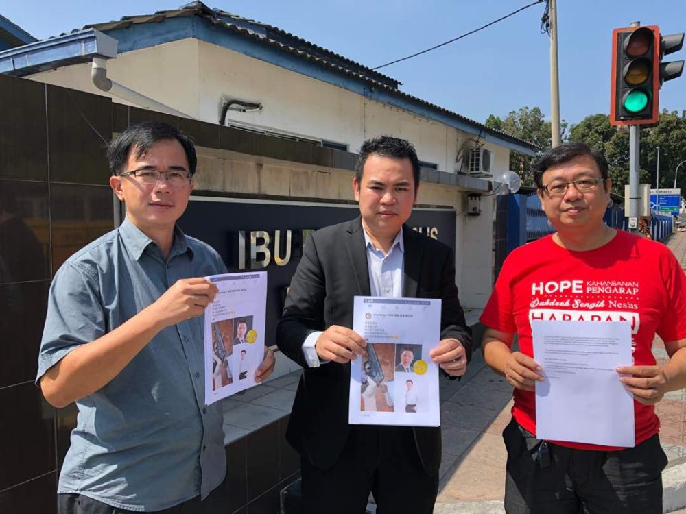 Keranji assemblyman Chong Zhemin (centre) lodged a police report over a Facebook user for posting criminal intimidation against Dewan Rakyat Deputy Speaker Nga Kor Ming and Deputy Defense Minister Liew Chin Tong. u00e2u20acu2022 Picture courtesy of Chong Zhemin