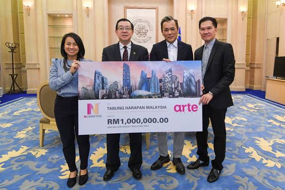 Finance Minister Lim Guan Eng receives the cheque for RM1 million from Nusmetro founding partners, Thomas Chan (second right) and Datuk Au Chee Fai (right). u00e2u20acu2022 Picture courtesy of Nusmetro Group