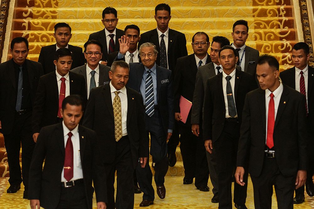 Prime Minister Tun Dr Mahathir Mohamad (centre) waves to members of the media as he leaves Parliament July 23, 2018. u00e2u20acu201d Picture by Miera Zulyana
