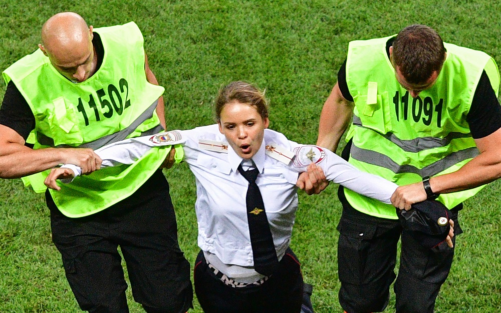 A pitch invader, a member of the Russian protest-art group Pussy Riot, is escorted by stewards during the Russia 2018 World Cup final football match in Moscow on July 15, 2018. u00e2u20acu201d AFP pic