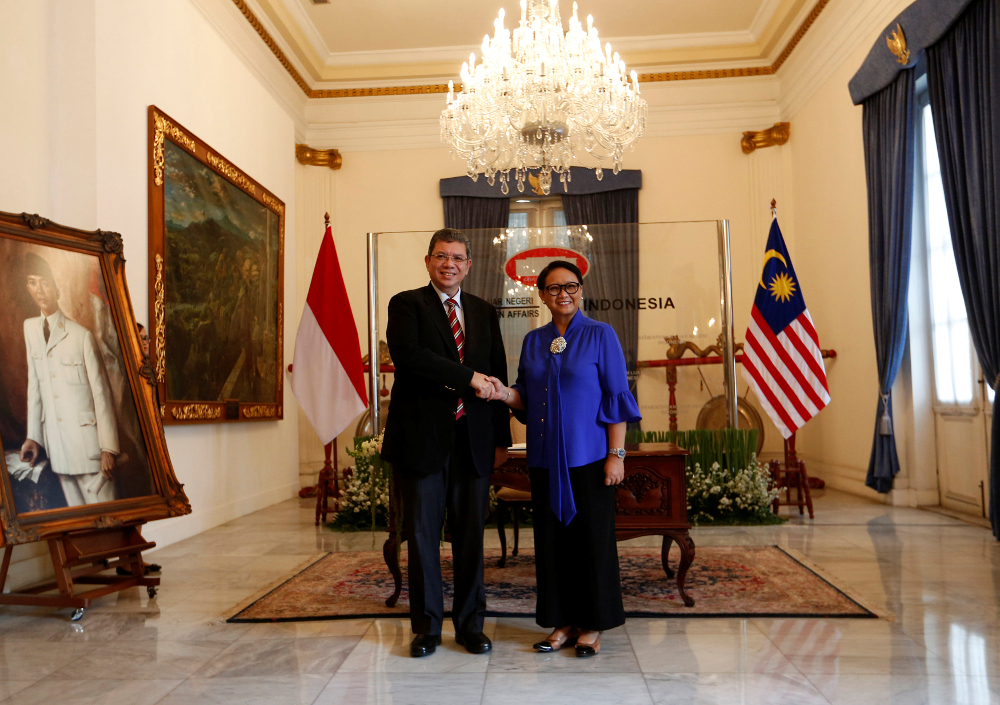 Indonesiau00e2u20acu2122s Foreign Minister Retno Marsudi (right) shakes hands with Malaysiau00e2u20acu2122s Foreign Minister Datuk Saifuddin Abdullah before their meeting in Jakarta July 23, 2018. u00e2u20acu201d Reuters pic