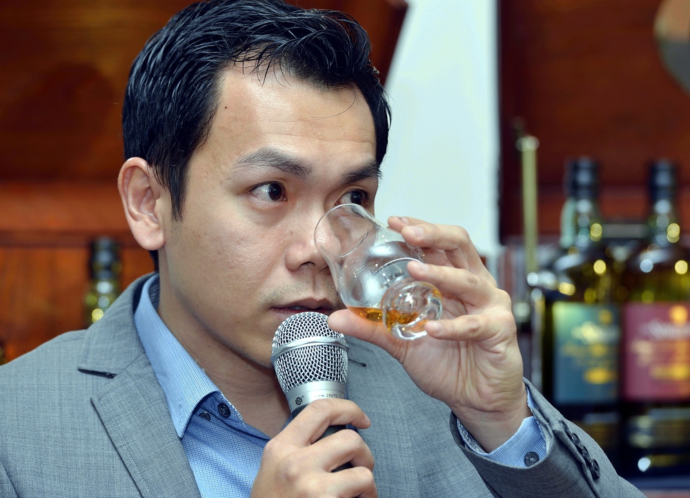 Ng demonstrates the right way to nose and taste whisky.