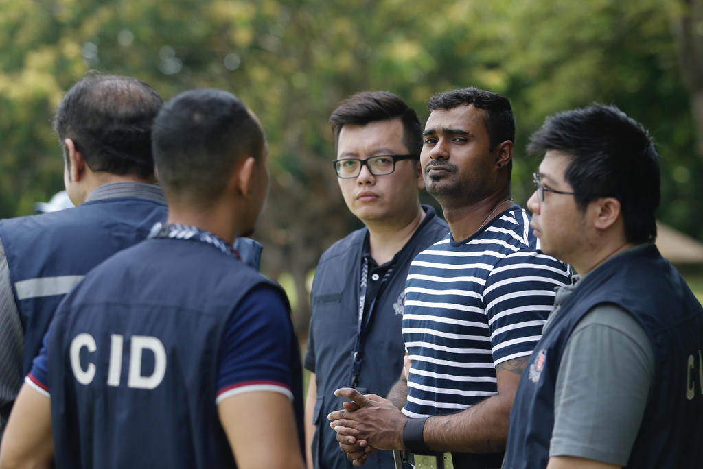 One of the suspects (in striped T-shirt) arrested over the slashing of a 27-year-old man on Serangoon Road being brought by the police to Lower Pierce Reservoir on Thursday. u00e2u20acu201d Najeer Yusof/TODAY pic