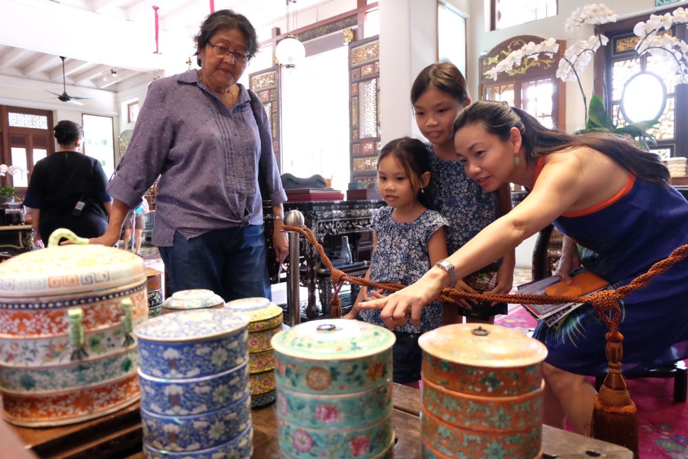 Visitors looking at the colourful porcelain tingkat on display at Seven Terraces.