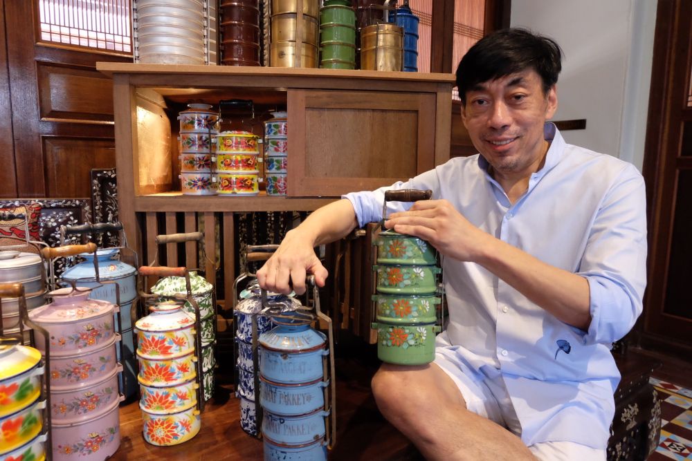 GTHH founder Chris Ong holding the two tiffin carriers that held bittersweet memories for him as those belonged to his parents. u00e2u20acu2022 Picture by KE Ooi