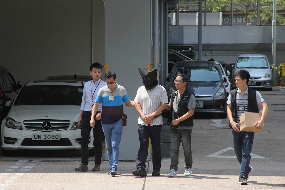 This handout photograph from Apple Daily shows Malaysian national Khaw Kim-sun (centre), who is accused of murdering his wife and daughter, being escorted by police at Ma On Shan Police Station in Hong Kong September 11, 2017. u00e2u20acu201d AFP pic