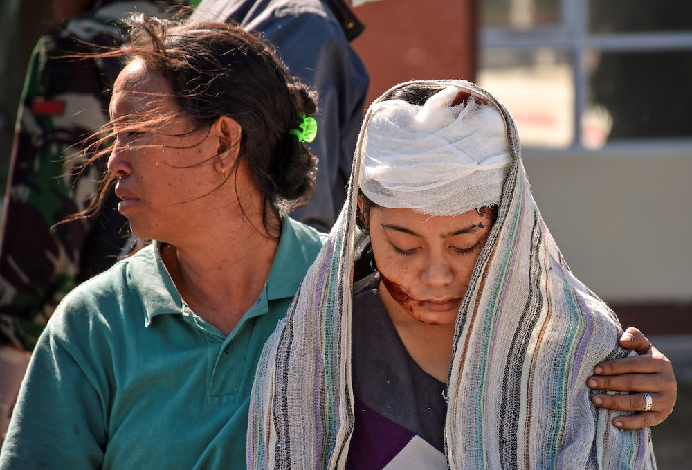 A woman injured during an earthquake walks outside the North Lombok Hospital in Tanjung, North Lombok August 6, 2018, in this photo taken by Antara Foto. u00e2u20acu201d Reuters pic