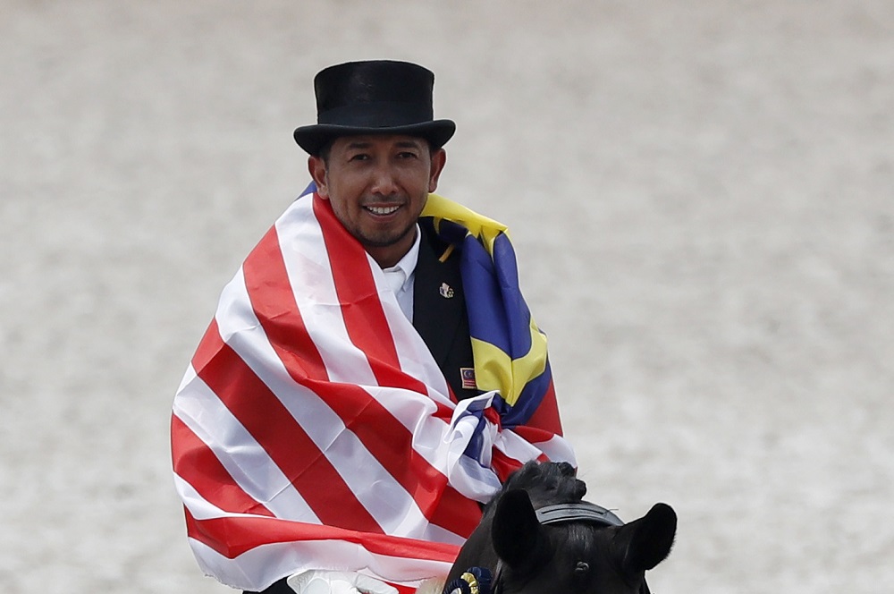 Silver medallist Mahamad Fathil Mohd Qabil Ambak riding Rosenstolz reacts during the Dressage Individual Intermediate 1 Freestyle victory ceremony in Jakarta August 23, 2018. u00e2u20acu201d Reuters pic