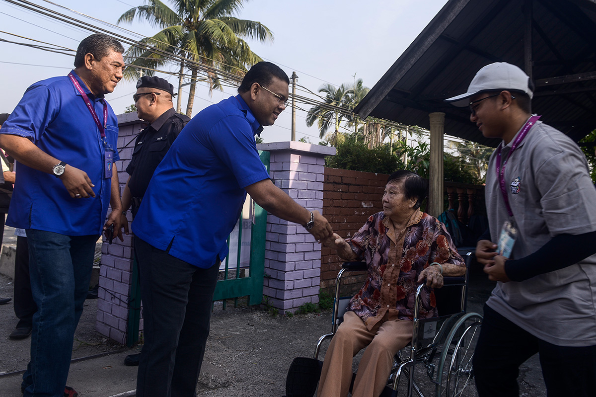 BNu00e2u20acu2122s Datuk Lokman Noor Adam  (centre) greets a voter at Sekolah Rendah Agama Sungai Kandis in Shah Alam August 4, 2018. u00e2u20acu201d Picture by Mukhriz Hazim