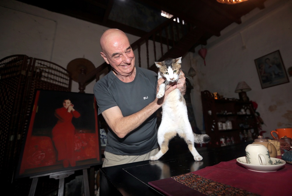 John Edward Lomax with his cat Tiffy at the 27 Concubine Lane Guest House in Ipoh. u00e2u20acu201d Picture by Farhan Najib