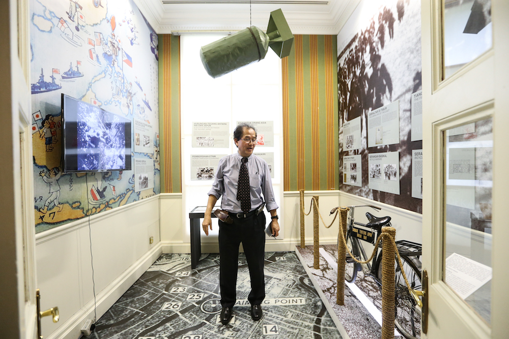 Tan stand next to a bicycle used by the Imperial Japanese Army during the Invasion of Malaya in a room featuring the Japanese Occupation of Malaya which is part of the Jalan Merdeka exhibition currently held at Carcosa. — Picture by Ahmad Zamzahuri
