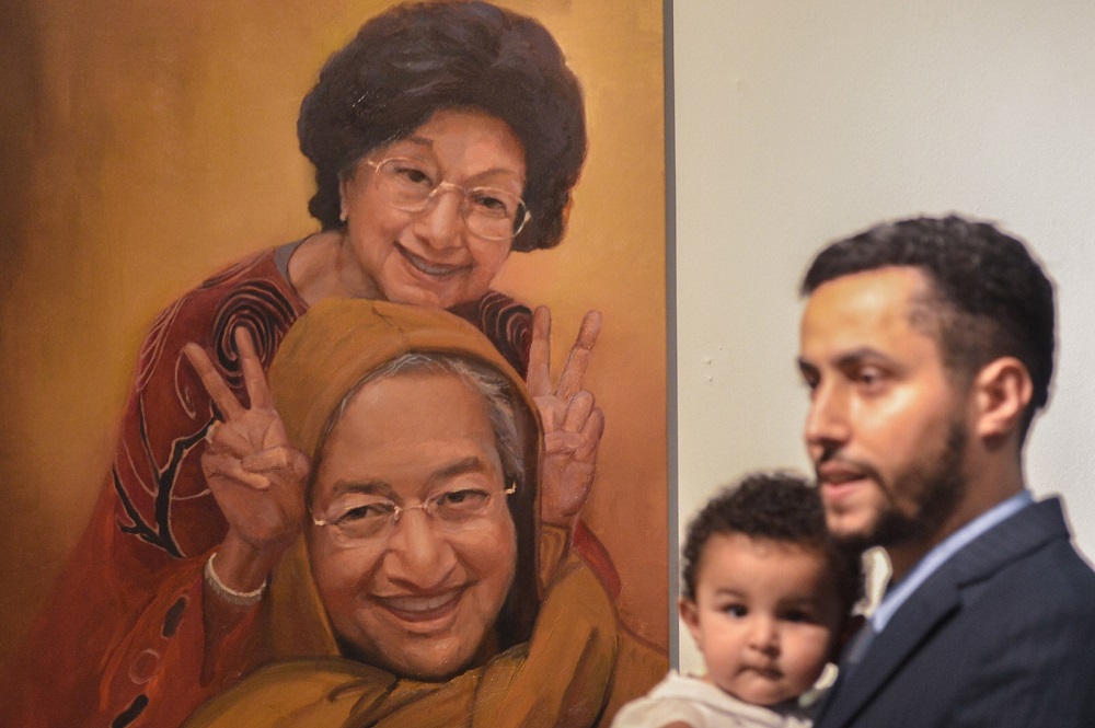 A visitor walks past a portrait of Tun Dr Mahathir Mohamad and Tun Dr Siti Hasmah at the u00e2u20acu02dcTun M: A forever legacyu00e2u20acu2122 art exhibition at Perdana University in Serdang  August 12, 2018. u00e2u20acu201dPictures by Mukhriz Hazimnn
