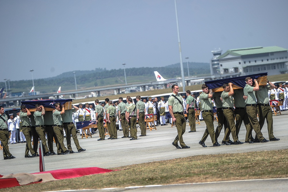 New Zealand armed forces personnel carry coffins during a ceremony to repatriate the remains of 27 New Zealand military personnel and their family at Bunga Raya complex August 20, 2018. 