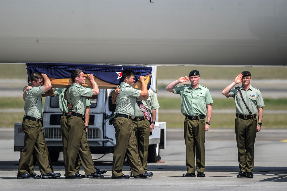 New Zealand armed forces personnel carry coffins during a ceremony to repatriate the remains of 27 New Zealand military personnel and their family at Bunga Raya complex August 20, 2018.