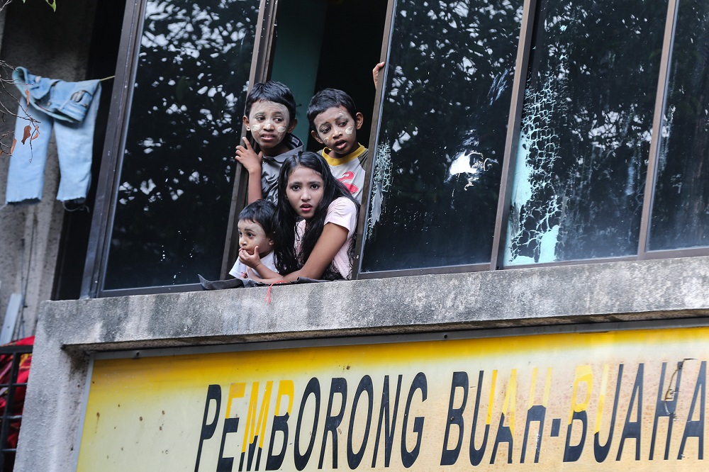 Children from the Rohingya community peer out a window from the top floor of a shoplot in Selayang August 22, 2018. u00e2u20acu201d Picture by Ahmad Zamzahuri