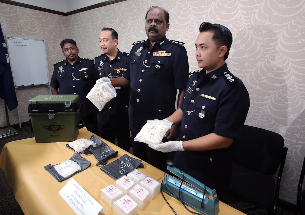 Assistant Superintendent Marafendi Marzuki and Perak police narcotics chief Assistant Commissioner VR Ravi Chandran hold the drugs seized from a house in Taman Klebang Mutiara, Ipoh August 27, 2018. u00e2u20acu201d Picture by Farhan Najib