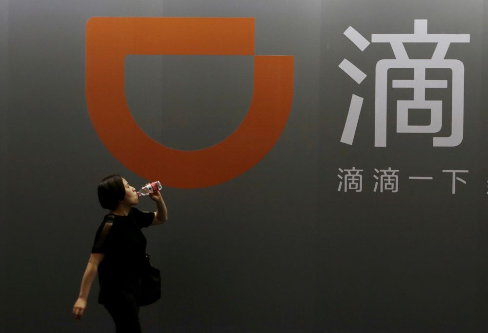 File photo of a woman walking past Didi Chuxingu00e2u20acu2122s booth at the Global Mobile Internet Conference (GMIC) 2017 in Beijing, China April 28, 2017. u00e2u20acu201d Reuters pic