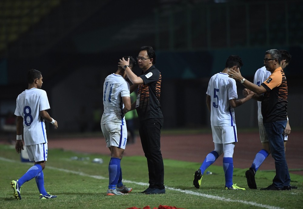 Datuk Ong Kim Swee consoles the national U-23 football squadu00e2u20acu2122s players after their 0-1 loss to Japan during the round of 16 at the 2018 Asian Games in Jakarta August 24, 2018. u00e2u20acu201d Bernama pic