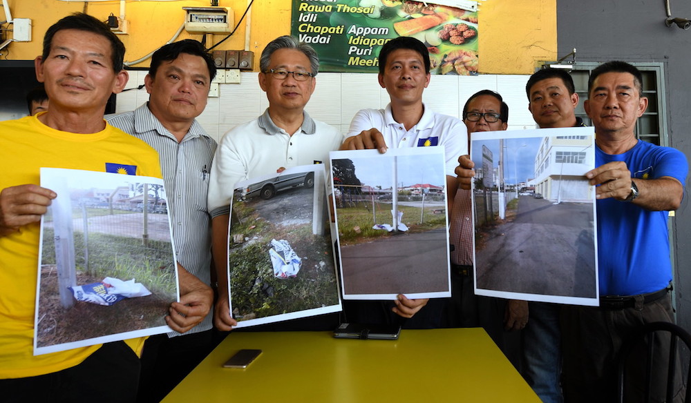 Tan Chee Teong (4th left) shows examples of the damaged campaign posters and buntings in Kuala Lumpur August 25, 2018. u00e2u20acu201d Bernama pic