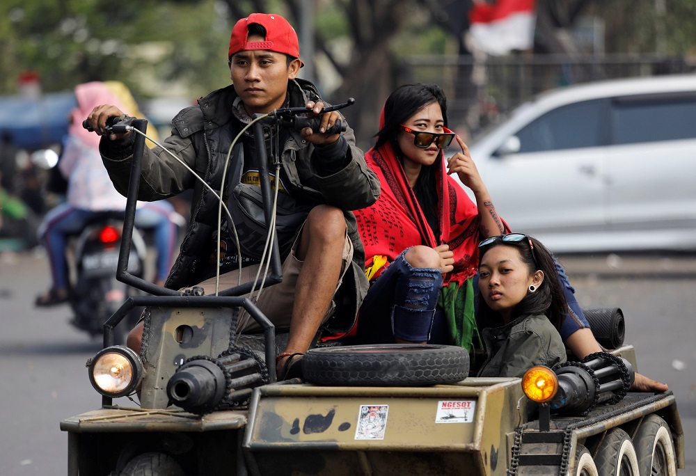 Extreme Vespa enthusiasts drive near the site of a weekend scooter festival in Kediri, East Java, Indonesia July 22, 2018. — Reuters pic