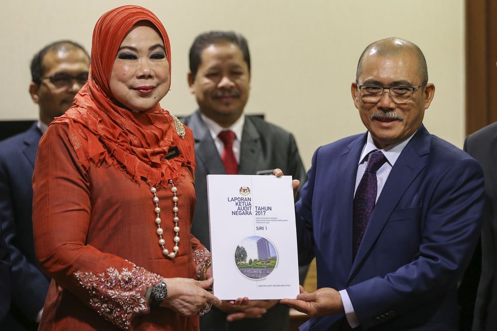 Tan Sri Madinah Mohamad (left) and Datuk Seri Dr Ronald Kiandee pose with a copy of the 2017 Auditor-General's Report in Parliament August 15, 2018. u00e2u20acu201d Picture by Azneal Ishak