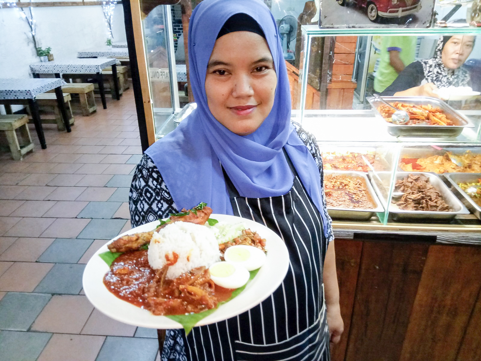 Noraziah with a plate of her famous 'nasi lemak'. u00e2u20acu201d Pictures by R. Rohaizam