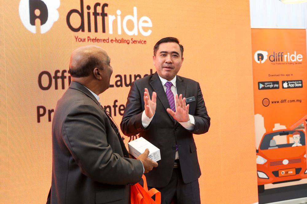 Anthony Loke refuses to accept a smartphone as a token of appreciation given by Joseph Herbert Louis, the director of the diffride e-hailing service, August 21, 2018. u00e2u20acu2022 Picture by Ahmad Zamzahuri