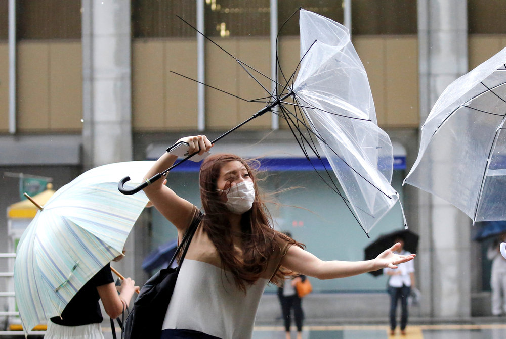 A woman using an umbrella struggles against a heavy rain and wind as Typhoon Shanshan approaches Japan's mainland in Tokyo August 8, 2018. u00e2u20acu201d Reuters pic