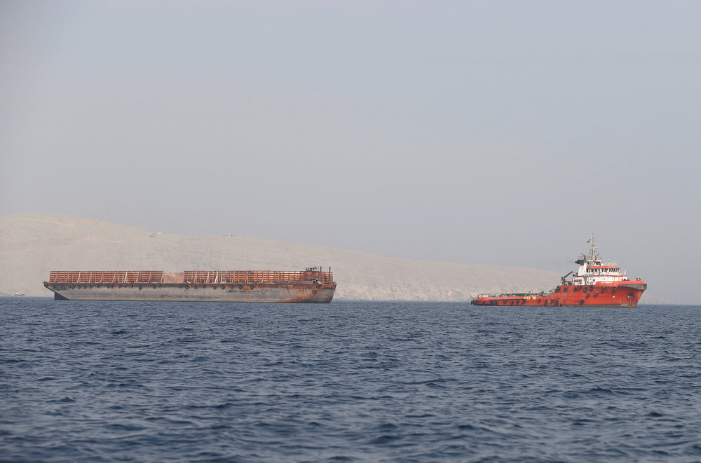 A tug boat moves cargo towards the Strait of Hormuz, in Musandam province, Oman July 20, 2018. u00e2u20acu201d Reuters image