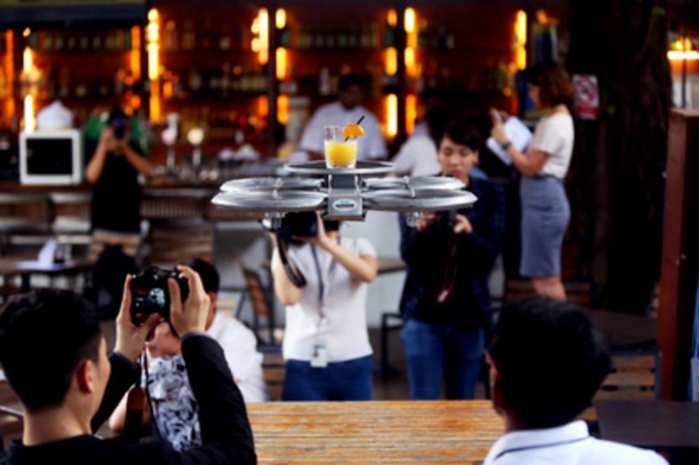 An Infinium-Serve flying robot taking off from a bar with a plate of snacks during a media demonstration at Timbre @ The Substation. u00e2u20acu201d TODAY file pic